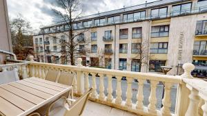 a balcony with a table and chairs and a building at White Lotus Hévíz - 50 m from Thermal Lake in Hévíz