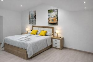 a bedroom with a bed with two yellow pillows at Casa Vidán completa Santiago Rural in Santiago de Compostela