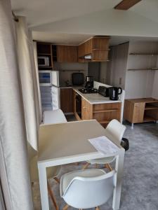 a small kitchen with a table and chairs in it at Lac des rêves in Lattes