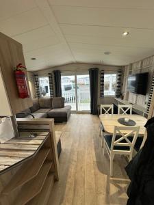 a living room with a couch and a table at Church meadow 39 in Pagham