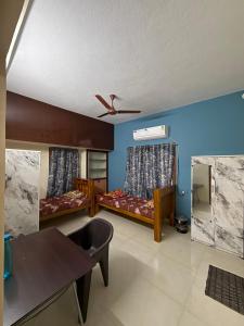 a living room with two beds and a table at APK living in Chennai