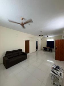 a living room with a couch and a ceiling fan at APK living in Chennai