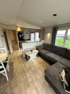 a living room with a couch and a table at Church meadow 39 in Pagham