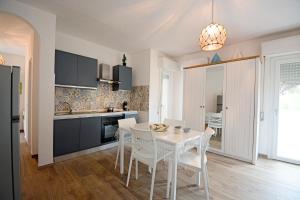 a kitchen with a white table and white chairs at Fidelica in Stintino