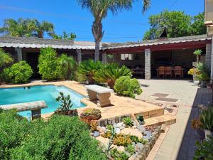 a backyard with a swimming pool and a house at Voni's Cottage in Vredendal