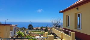a balcony of a house with a view of the ocean at Calheta Countryside in Calheta