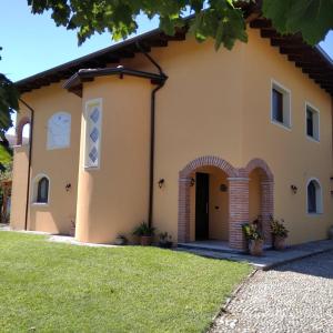 a large yellow house with an arch doorway at B&b Villa Sofia in Fara Novarese