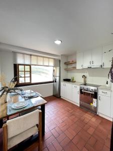a kitchen with white cabinets and a table and a counter at Modern Apartment with Private Balcony in Quito