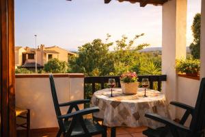 a table with two glasses of wine on a balcony at Casa Vacanze Paola 2 in Santa Luria