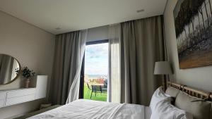 a bedroom with a bed and a window with a view at Sifah BF 508B in As Sīfah