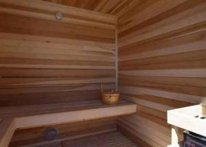 a small wooden sauna with a bucket in it at ממלכת החלומות - וילה מהממת עם בריכה פרטית מחוממת מקורה ונוף מהמם in ‘Ein el Asad