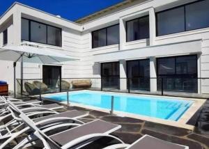 a house with a swimming pool and chairs at ממלכת החלומות - וילה מהממת עם בריכה פרטית מחוממת מקורה ונוף מהמם in ‘Ein el Asad