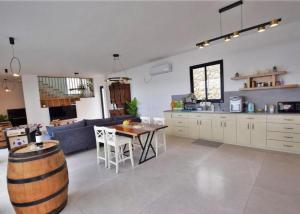 a kitchen and living room with a table and a couch at ממלכת החלומות - וילה מהממת עם בריכה פרטית מחוממת מקורה ונוף מהמם in ‘Ein el Asad