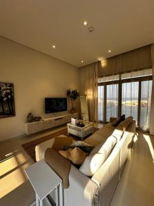 a living room with a large couch and a tv at Sifah BF 508B in As Sīfah