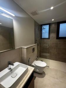 a bathroom with a sink and a toilet and a mirror at Sifah BF 508B in As Sīfah +6 photos