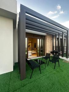 a yard with chairs and a patio with green grass at Sifah BF 508B in As Sīfah