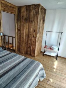 a bedroom with a bed and a wooden wall at Sol de Caraúbas in Caraúbas