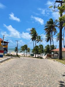 an empty road with palm trees on the beach at Sol de Caraúbas in Caraúbas