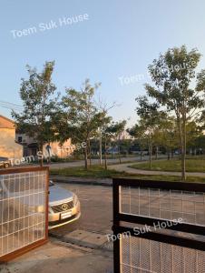 a car parked in a parking lot with a gate at เติมสุขเฮาส์ Toem Suk House in Ban Bang Luk