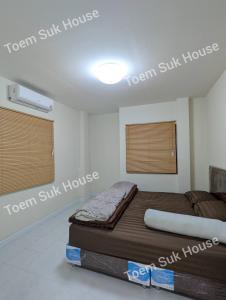a bedroom with a bed and two windows at เติมสุขเฮาส์ Toem Suk House in Ban Bang Luk