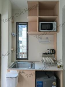 a small kitchen with a sink and a microwave at เติมสุขเฮาส์ Toem Suk House in Ban Bang Luk +4 photos