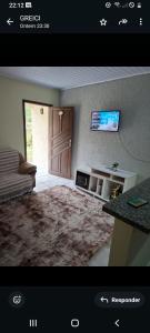 a view of a living room with a door and a television at Sitio4meninos in Pinheiral