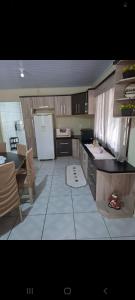 a kitchen with wooden cabinets and a white refrigerator at Sitio4meninos in Pinheiral