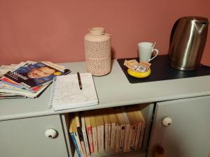 a desk with a pen and books on it at Chambre cosy avec piscine in Saint-Benoît +2 photos