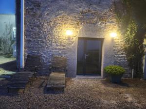 a group of chairs sitting outside of a building at night at Gîte de Burgy in Burgy