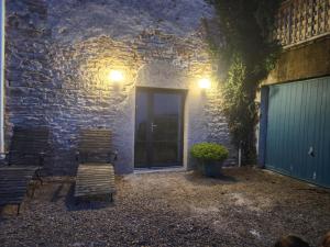 a patio with two chairs and a door at night at Gîte de Burgy in Burgy