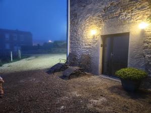 two benches sitting outside of a building at night at Gîte de Burgy in Burgy