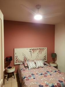a bedroom with a bed with a large headboard at Chambre cosy avec piscine in Saint-Benoît