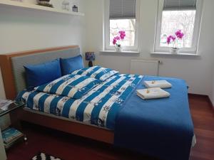 a bedroom with a blue bed with two towels on it at Apartament B & S - Free Garage Parking in Szczecin +47 photos