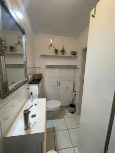 a small bathroom with a toilet and a sink at Kleines Glück Grömitz in Grömitz +5 photos