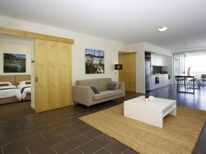 a living room with a couch and a table at Grand Mercure Apartments Magnetic Island in Nelly Bay