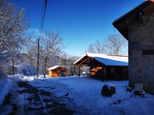 a log cabin with snow on the ground at Maisonnette cocooning, ancien four à pain in Saint-Éloy-la-Glacière
