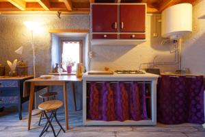 a kitchen with a stove and a counter with a table at Maisonnette cocooning, ancien four à pain in Saint-Éloy-la-Glacière