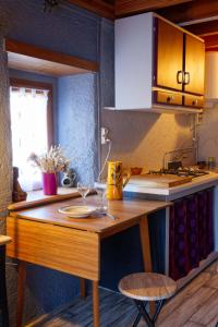 a kitchen with a wooden counter top with a table at Maisonnette cocooning, ancien four à pain in Saint-Éloy-la-Glacière