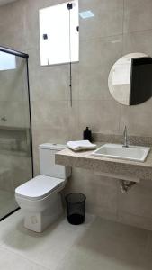 a bathroom with a toilet and a sink and a mirror at Bela Gold Alto Caparaó in Caparaó Velho +2 photos