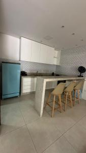a kitchen with a counter with chairs and a blue refrigerator at Bela Gold Alto Caparaó in Caparaó Velho