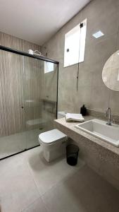 a bathroom with a shower and a toilet and a sink at Bela Gold Alto Caparaó in Caparaó Velho
