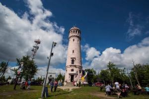 a white lighthouse in a park with people standing around it at Blu Apartments -Rynek in Nowa Ruda