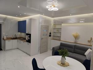a kitchen and living room with a table and a couch at Blu Apartments -Rynek in Nowa Ruda