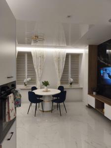 a dining room with a white table and chairs at Blu Apartments -Rynek in Nowa Ruda