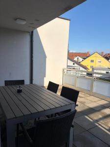 a wooden table and chairs on a balcony at Ruhige Wohnung in Linz +10 photos