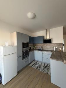 a kitchen with white appliances and blue cabinets at Ruhige Wohnung in Linz