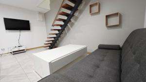 a living room with a couch and a staircase at Le Grand Minck in Grand-Fort-Philippe