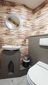 a bathroom with a toilet and a sink and a mirror at Le Grand Minck in Grand-Fort-Philippe
