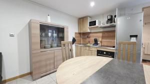a kitchen with wooden cabinets and a table at Le Grand Minck in Grand-Fort-Philippe
