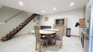 a kitchen with a table and chairs and a staircase at Le Grand Minck in Grand-Fort-Philippe +14 photos